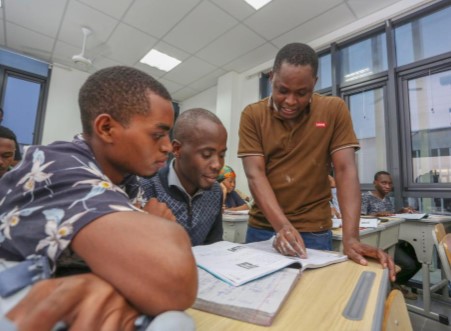 Emmanuel Richard Legonga (1st R, front), a Tanzanian teacher who has worked at the Confucius Institute for eight years, teaches local youths to learn Chinese in Dar es Salaam, Tanzania 
